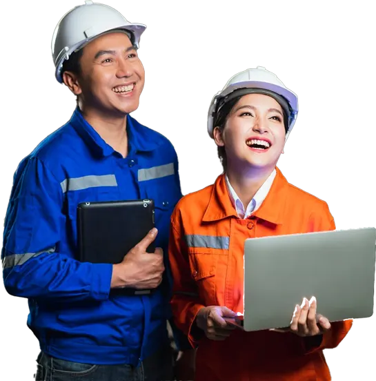 Two Asian men and a woman, equipped with hard hats and safety glasses, engage with a laptop in a construction environment.